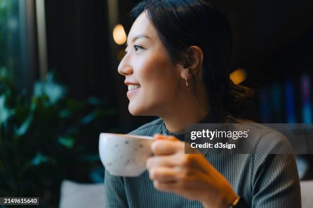 close-up shot of beautiful smiling young asian woman relaxing with a cup of coffee in cafe, enjoying a peaceful morning to start off a day. people, food and lifestyle - view-through-restaurant-window stock pictures, royalty-free photos & images