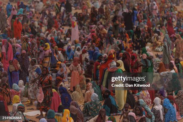 Refugees, mostly women and children wait for a WFP food distribution point to open at a temporary camp on April 22, 2024 in Adre, Chad. Since the...