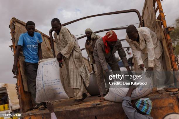 Aid is unloaded ready to hand out to refugees at a WFP food distribution point to open at a temporary camp on April 22, 2024 in Adre, Chad. Since the...