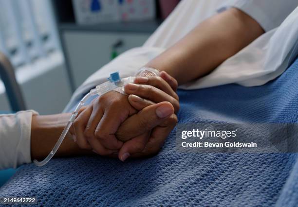 nurse and kid patient holding hands with care, help and support in hospital with closeup. child, healthcare professional and wellness check with people for recovery and rehabilitation after surgery - holding hands stock pictures, royalty-free photos & images
