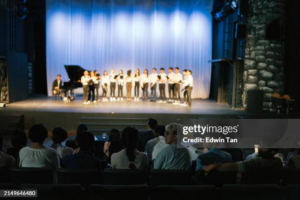 asiatisch-chinesischer chor chorus performance gruppe singen auf der bühne mit publikum zuschauen - klassisches konzert stock-fotos und bilder