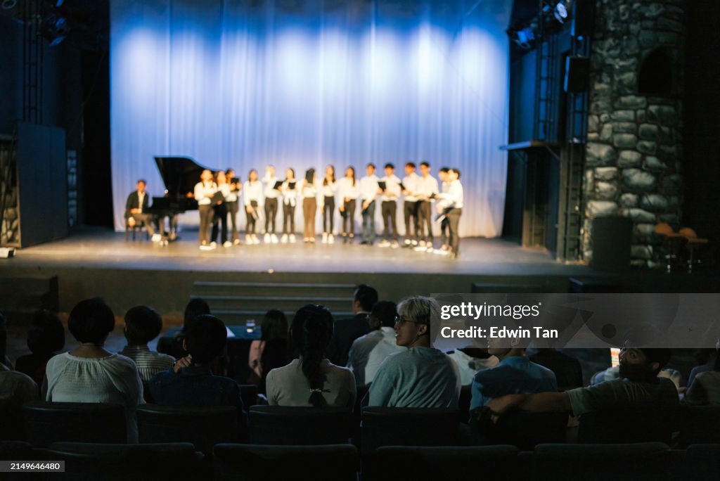 Asian Chinese Choir chorus performance group Singing on stage with audience watching