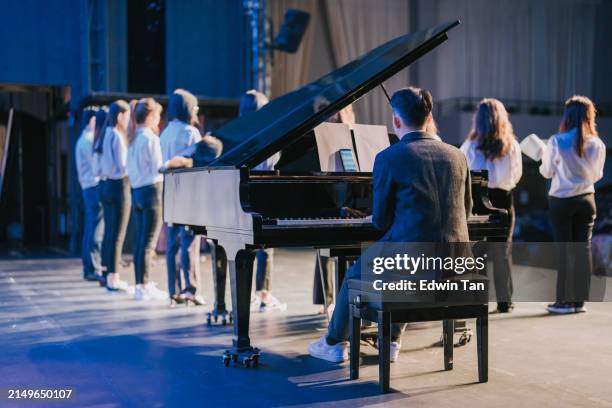 asiatisch-chinesischer pianist und chor-performance-gruppe singen auf der bühne - chorsänger stock-fotos und bilder