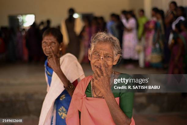 People from Kattunayakar tribe display inked fingers after casting their vote at a polling station during the second phase of voting of India's...