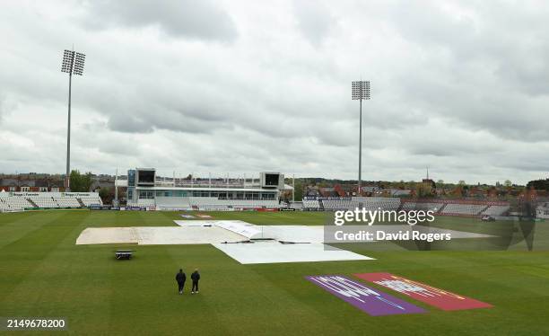 The umpires walk out to inspect the square as play is delayed due to rain during the Vitality County Championship division two match between...