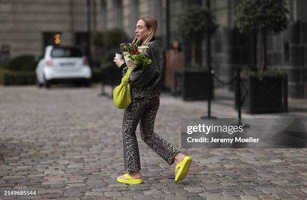 Sonia Lyson seen wearing black sunglasses, grey faded vintage oversized bomber leather jacket, beige / brown leopard print pattern jeans pants, lime...