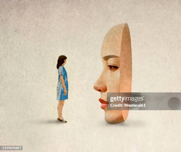 woman standing in front of oversized mask against beige background - name change stock illustrations