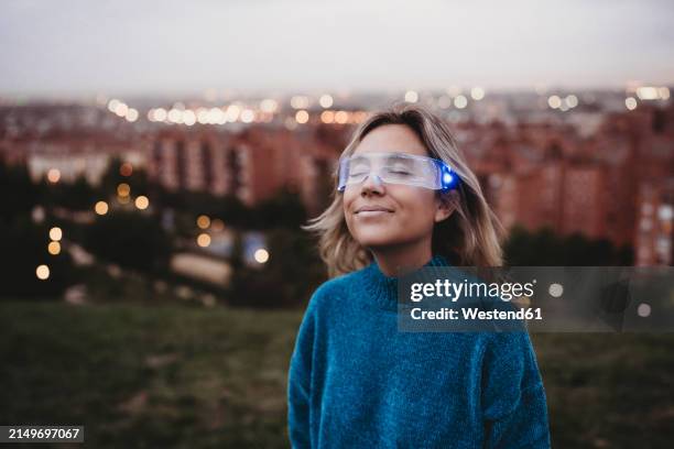 woman wearing futuristic glasses at dusk - datenbrille stock-fotos und bilder