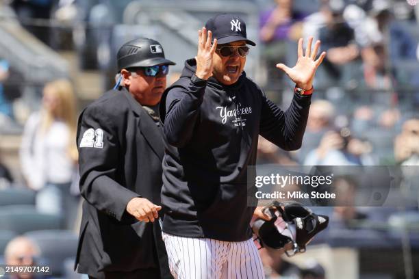 Aaron Boone of the New York Yankees argues with home plate umpire Hunter Wendelstedt in the first inning during the game against the Oakland...