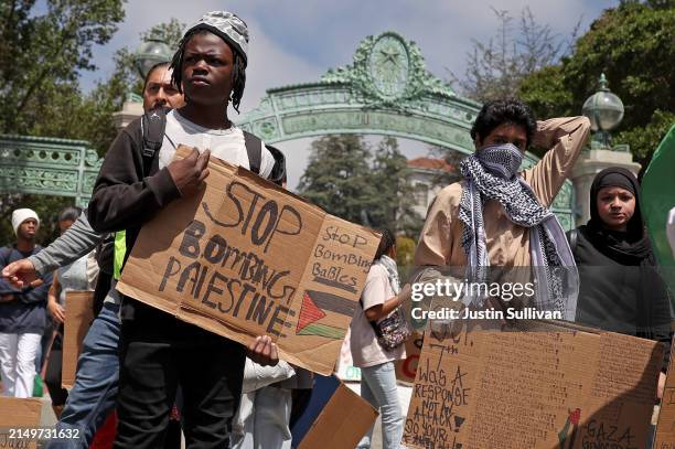 Pro-Palestinian protesters carry signs as they march in front of Sather Gate on the UC Berkeley campus on April 22, 2024 in Berkeley, California....
