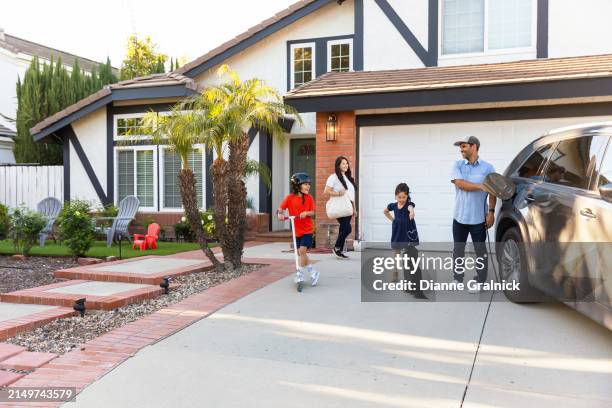 familia con vehículo eléctrico - camino de entrada fotografías e imágenes de stock