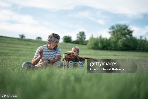family day. dad & kid play music in nature in spring. - affectionate stock pictures, royalty-free photos & images