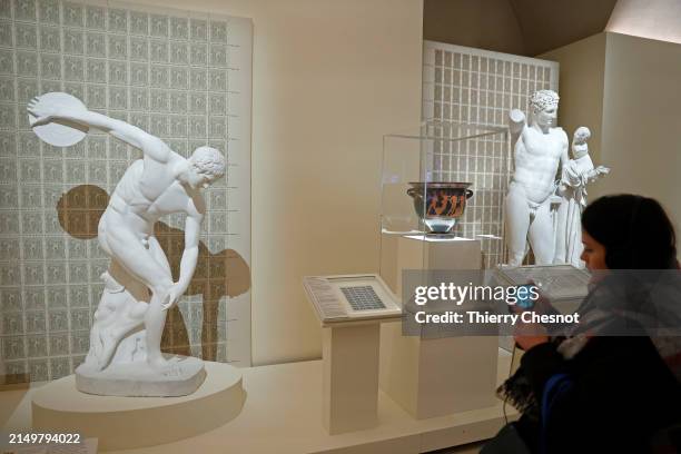 Visitor takes a picture of the "Discobolus" by Myron during the exhibition "Olympism. A modern invention, an ancient heritage" at the Louvre Museum...