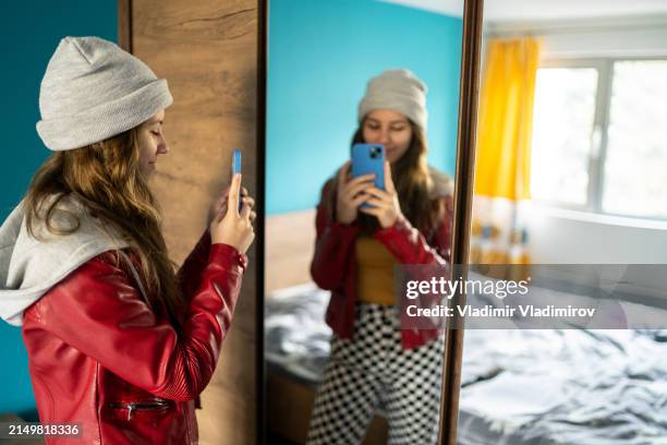 young woman taking a photo of herself - girl bobble hat stock pictures, royalty-free photos & images