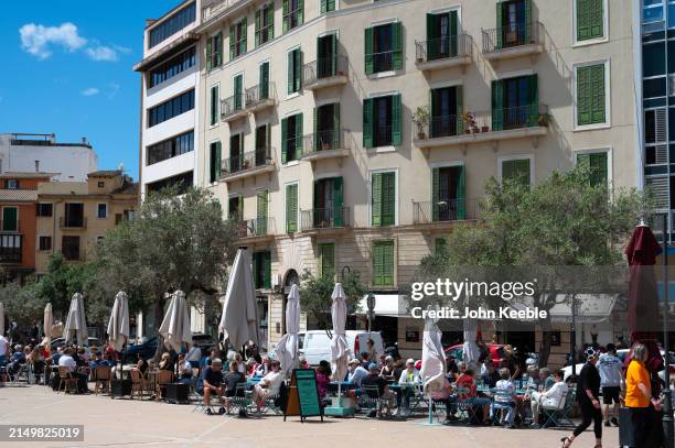 People sit and dine outside the Mercat de l’Olivar fresh food market on April 17, 2024 in Palma de Mallorca, Spain.
