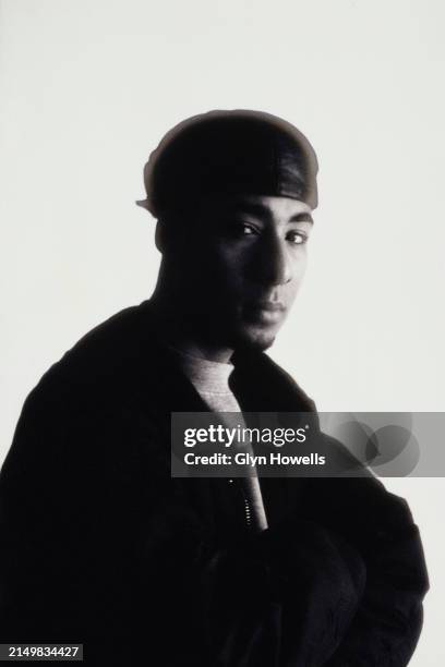 Male fashion model is posed wearing a bomber jacket and leather hat in a studio, circa 1992.