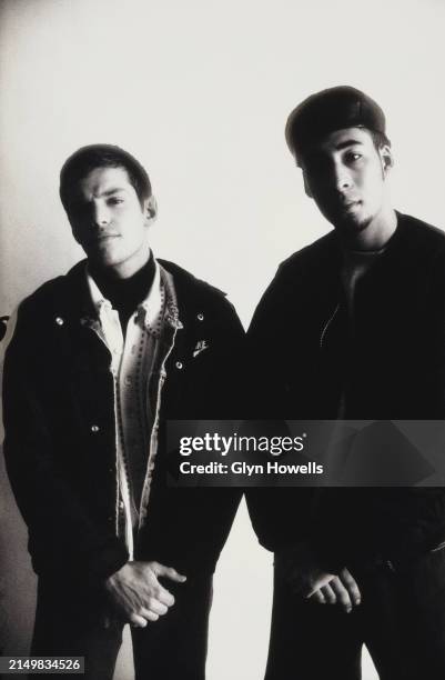Two male fashion models posed in a studio, circa 1992. The man on the left is wearing a 'yardie' cardigan and Nike jacket, the man on the right is...