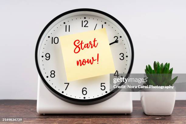 start now text on adhesive note and alarm clock - linea di partenza attrezzatura sportiva foto e immagini stock