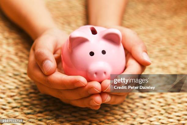 schoolboy holding piggy bank - budding tween stock pictures, royalty-free photos & images