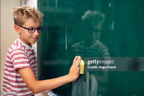 little boy cleaning the chalkboard before the lesson - task board stock pictures, royalty-free photos & images