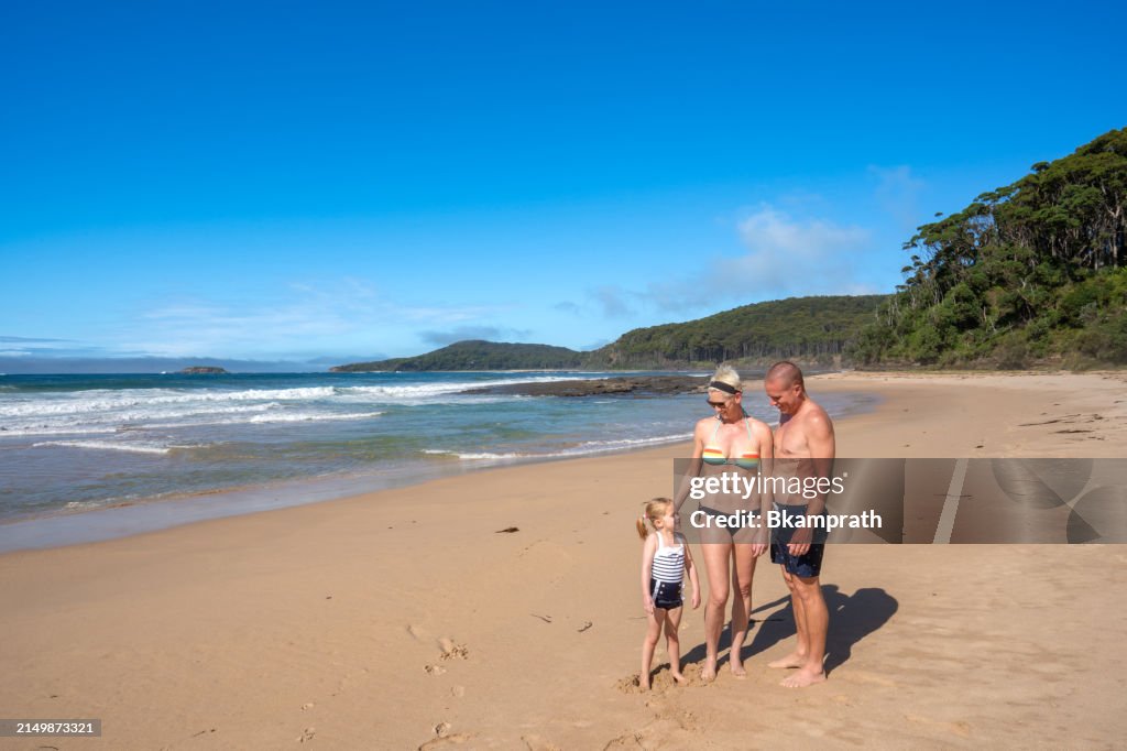 Mother, Father, and Daughter exploring a Beautiful Sandy Beach in Eastern Australia