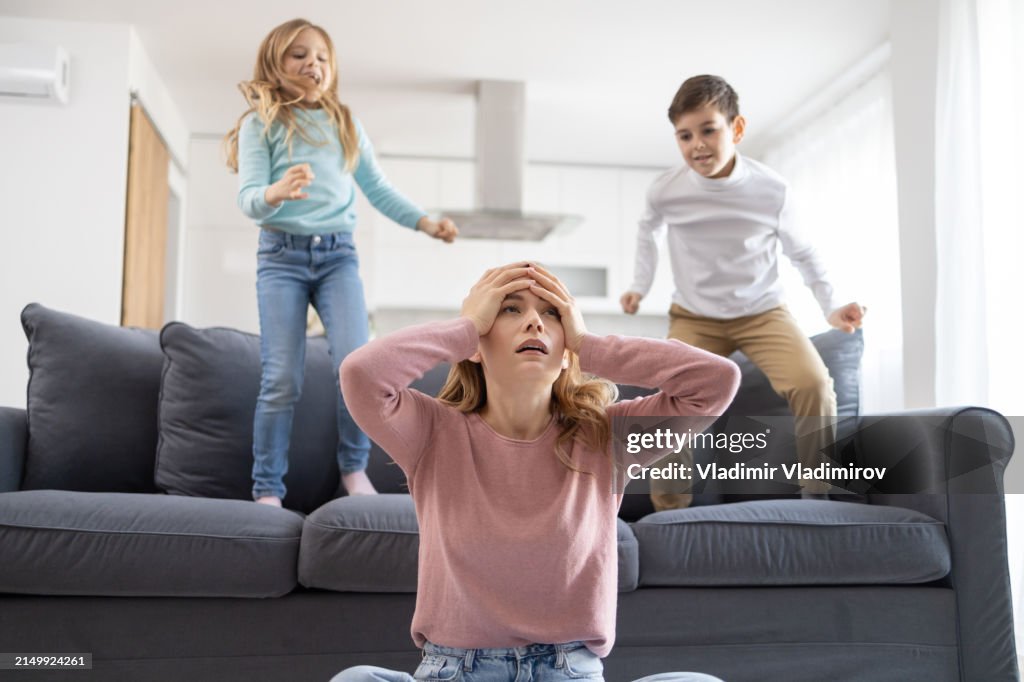 Overwhelmed mother with playful kids