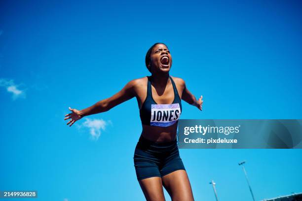 international athlete celebrating victory with open arms and shouting. emotional sports achievement outdoor portrait with blue sky. triumph and passion concept. - passion stock pictures, royalty-free photos & images