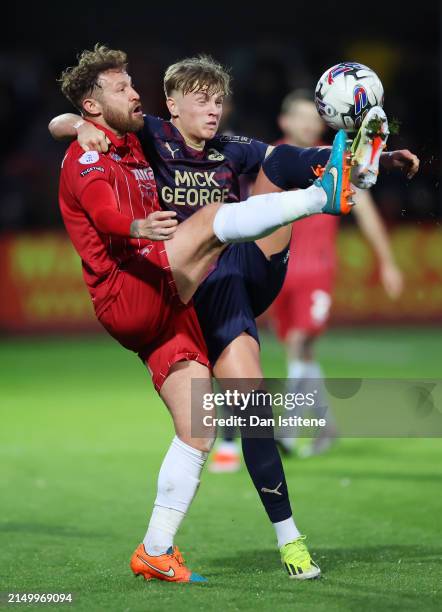 Matty Taylor of Cheltenham Town battles for the ball with Harley Mills of Peterborough United during the Sky Bet League One match between Cheltenham...