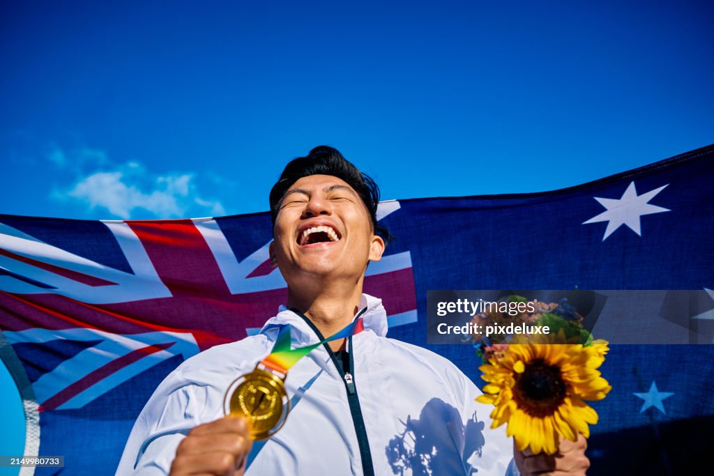 Ecstatic athlete with medal and sunflower bouquet against Australian flag. Joyful victory celebration outdoor portrait. National pride and achievement concept.
