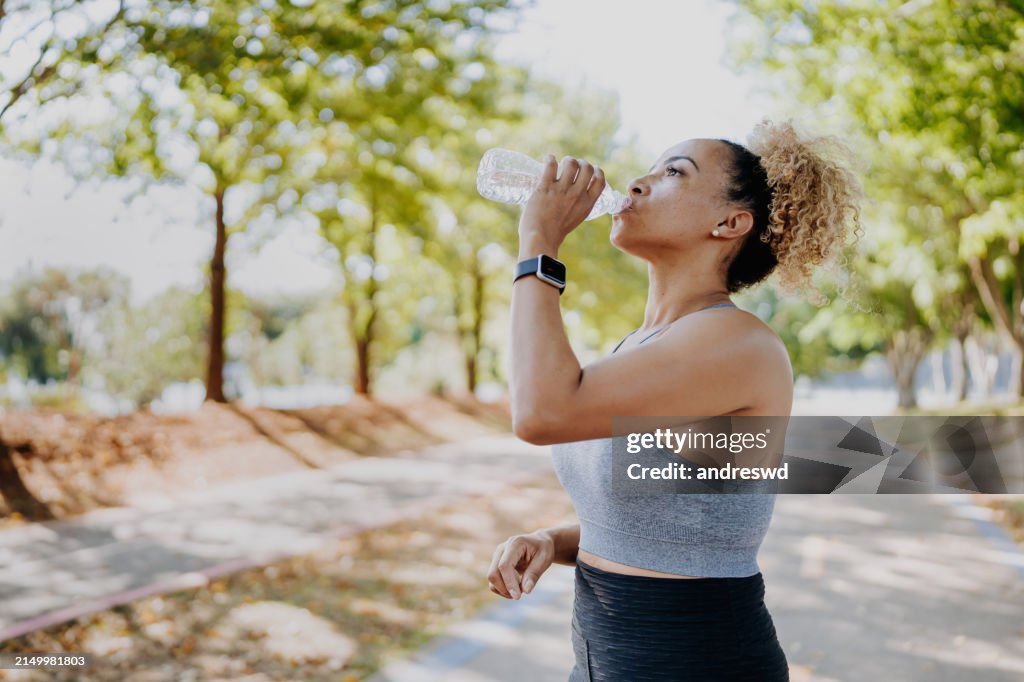 Fitness runner woman drinking water
