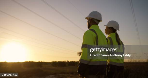 teamwork, electrical engineer and construction in power station with sunset for electricity inspection and tower check. engineering, rear view or collaboration for energy distribution and maintenance - telephone lines stock pictures, royalty-free photos & images