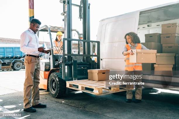 warehouse workers unloading shipment - black van stock pictures, royalty-free photos & images