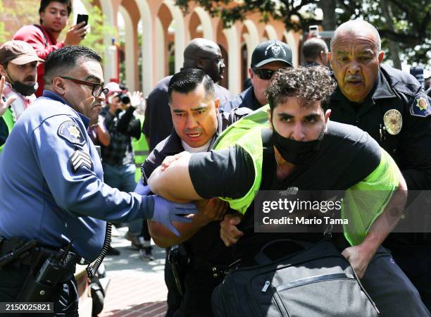 Public safety officers detain a pro-Palestine demonstrator during clashes after officers attempted to take down an encampment in support of Gaza at...