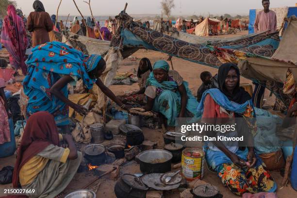 Newly arrived Sudanese refugees cook food over fires outside their makeshift shelters at a relocation camp on April 24, 2024 near Adre, Chad. Since...