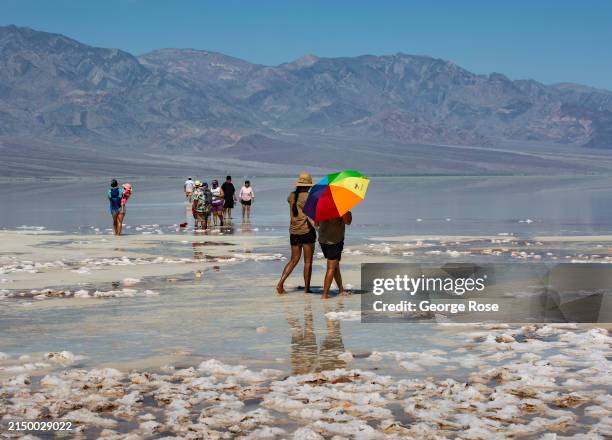 Badwater Basin, home to Lake Manly, is viewed on a 100 degree spring day as people walk on the salt flats around what's left of the lake on April 23...