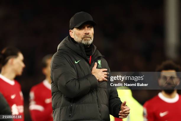 Jurgen Klopp, Manager of Liverpool, holds the Liverpool badge on his coat after the team's defeat in the Premier League match between Everton FC and...