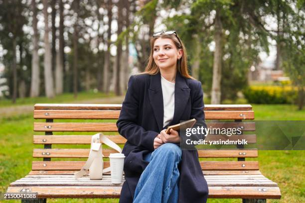 blonde studentin studiert auf bank auf dem universitätscampus - ivy league universitäten stock-fotos und bilder