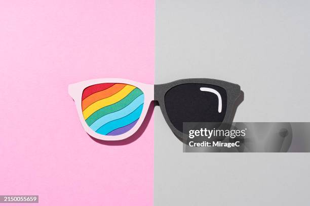 style choosing: novelty rainbow sunglasses or classic black sunglasses - gegensatz stock-fotos und bilder
