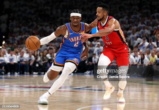 Shai Gilgeous-Alexander of the Oklahoma City Thunder drives to the basket as CJ McCollum of the New Orleans Pelicans defends during the first half of...