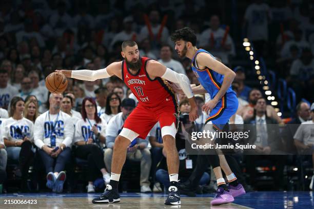 Jonas Valanciunas of the New Orleans Pelicans controls the ball as Chet Holmgren of the Oklahoma City Thunder defends during the first half of game...