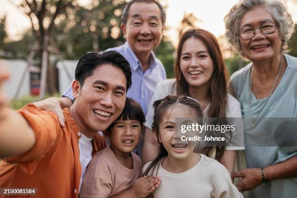 capturing happy family moments - asian family photo stock pictures, royalty-free photos & images