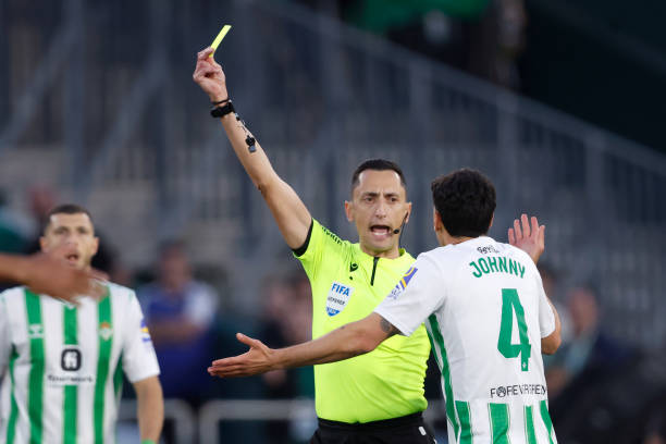 Referee Jose Sanchez gives a yellow card during the LaLiga EA Sports match between Real Betis Sevilla v Sevilla at the Benito Villamarin Stadium on...