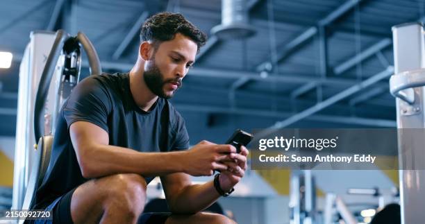 exercise, smartphone and man in gym, typing and contact with email, check training schedule and online fitness news. person, athlete and guy in wellness center, relax and cellphone with workout goals - scrolling stock pictures, royalty-free photos & images