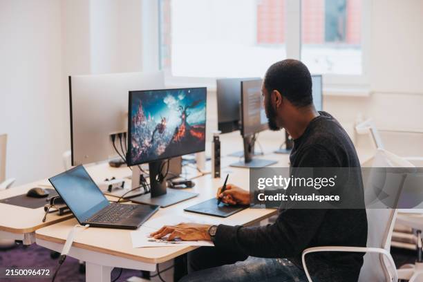 designer di videogiochi africano, al lavoro su un nuovo videogioco - studio di design foto e immagini stock