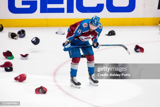 Valeri Nichushkin of the Colorado Avalanche leans over and watches hats fall to the ground after scoring his third goal of the game in the third...