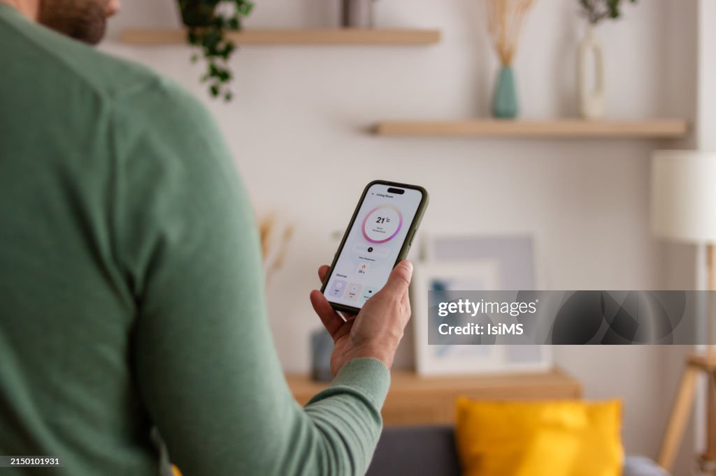 Hombre controlando el termostato inteligente desde un teléfono inteligente