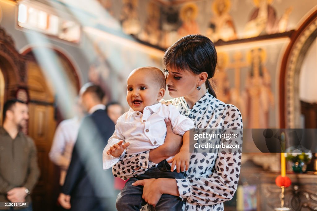 Young Mother Holding Her Baby During Christening In Orthodox Church