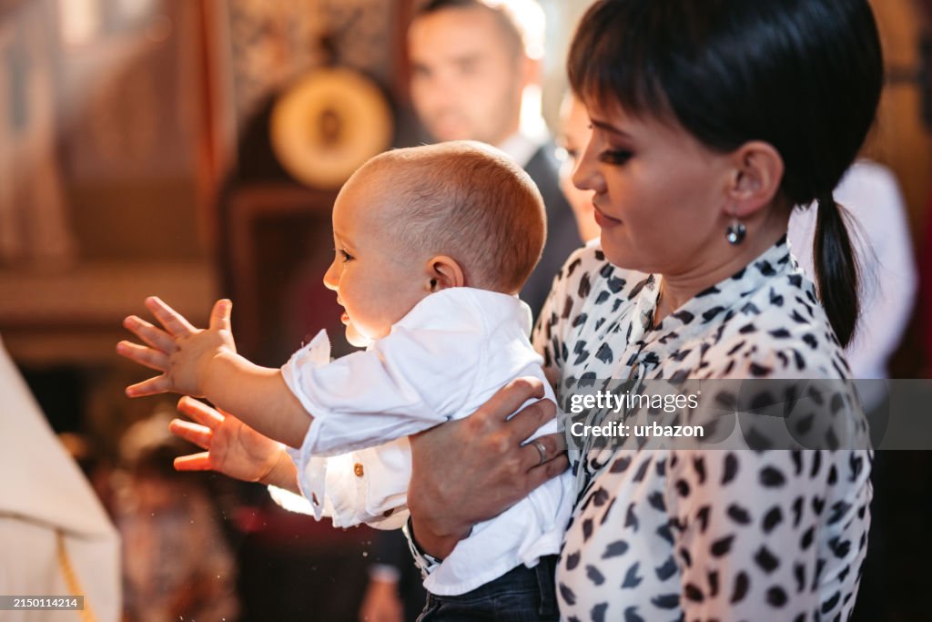 Young Mother Holding Her Baby During Christening In Orthodox Church