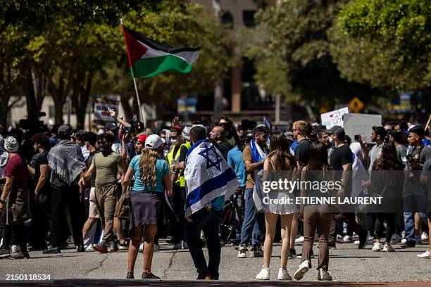 Pro-Israeli demonstrators look at as pro-Palestinian demonstrators protest on the campus of the University of California Los Angeles , in Los Angeles...