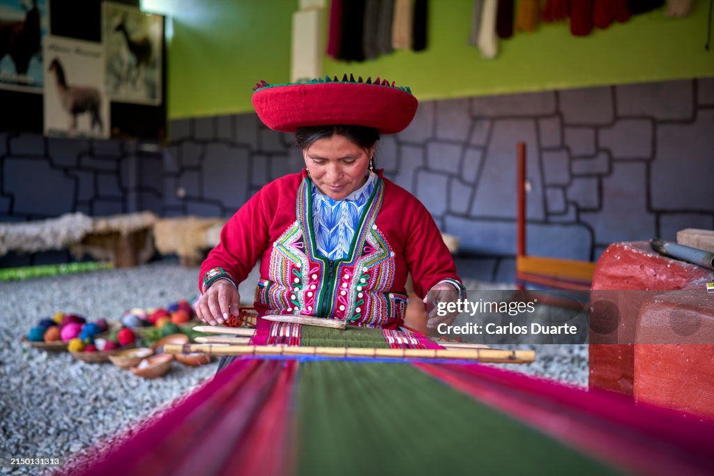 Peruvian indigenous woman from the town of Chinchero weaving cloth made with alpaca animal hair